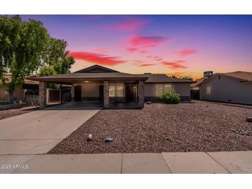 Inviting single-story home featuring a large covered parking area and low maintenance desert landscaping at 137 W Wagoner Rd, Phoenix, AZ 85023