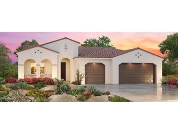 Elegant, single story home with a terracotta roof, a lush front yard, and a convenient two-car garage at 3566 N 166Th Dr, Goodyear, AZ 85395