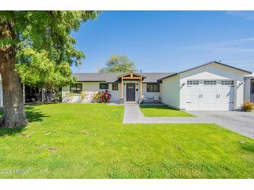 Charming single-story home featuring a well-manicured lawn and inviting entrance at 4842 E Fairmount Ave, Phoenix, AZ 85018