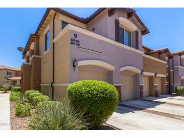 Inviting townhouse featuring a two-car garage, manicured shrubs, and modern architectural details at 7726 E Baseline Rd # 125, Mesa, AZ 85209