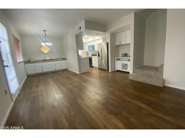 Open-concept living room and kitchen with stainless steel appliances and modern white cabinetry at 10828 N Biltmore Dr # 133, Phoenix, AZ 85029