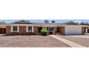Charming brick home featuring a well-maintained yard and attached garage at 1541 E Glencove St, Mesa, AZ 85203