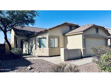 Tan home featuring a tile roof, two-car garage, and desert landscaping at 1630 W Pecan Rd, Phoenix, AZ 85041