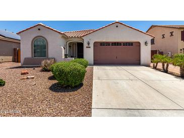 Charming single-story home features a well-maintained front yard with a two car garage and a tiled roof at 18669 W Vista Norte St, Goodyear, AZ 85338