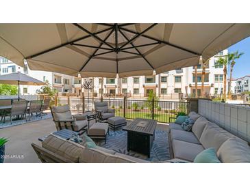Spacious patio featuring an outdoor seating area, fire pit, and umbrella at 2511 W Queen Creek Rd # 166, Chandler, AZ 85248
