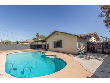 An inviting backyard pool is surrounded by ample patio space and landscaping, perfect for outdoor entertaining at 4238 W Krall St, Phoenix, AZ 85019