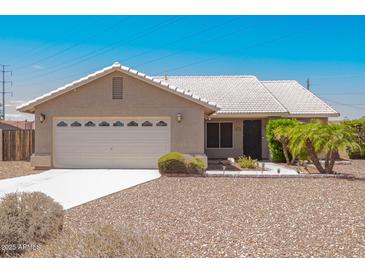 Charming single-story home with a two-car garage, desert landscaping and a light tile roof at 1063 W Vaughn St, Tempe, AZ 85283