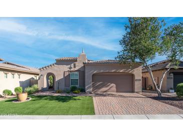 Single-story home with a neutral-colored stucco exterior, tile roof, brick driveway, and arched entry at 1123 W Thunderhill Dr, Phoenix, AZ 85045
