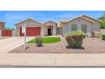 Charming single-story home featuring a red garage door and desert landscaping at 11306 E Rembrandt Ave, Mesa, AZ 85212