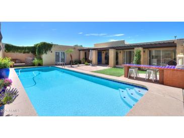 The long, sparkling backyard pool offers a refreshing escape, with a built-in barbecue nearby for outdoor entertaining at 1131 N Cherry --, Mesa, AZ 85201