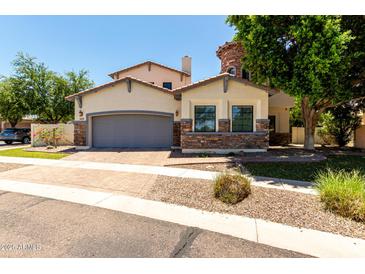 Beautiful home with neutral stucco, stone accents, two car garage, and mature landscaping at 3229 E Mountain Village Cir, Phoenix, AZ 85042