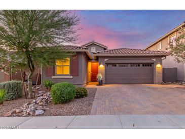 Charming single-story home with a paver driveway and a two-car garage at dusk at 4152 W Bradshaw Creek Ln, New River, AZ 85087