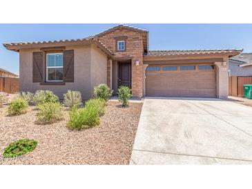 Charming single-Gathering home with a well-manicured front yard, a two-car garage, and stone masonry at 4371 E Enmark Dr, San Tan Valley, AZ 85143