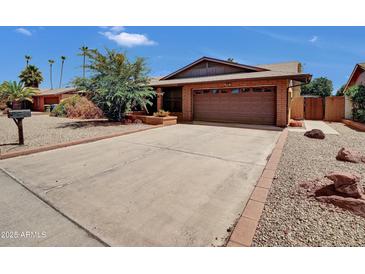 Charming single-story home with a brick exterior and well-maintained desert landscaping, plus a large driveway at 4509 E Joan De Arc Ave, Phoenix, AZ 85032