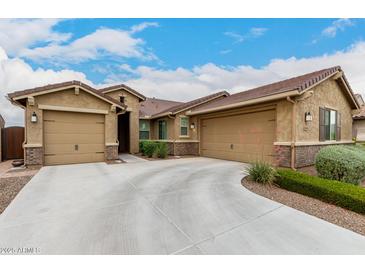 Charming single-story home with a three-car garage and a beautifully landscaped front yard with desert landscaping at 18368 W Long Lake Rd, Goodyear, AZ 85338