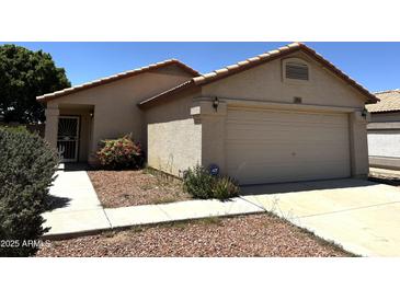 Single-story home featuring a neutral color scheme, two-car garage, and desert landscaping for a modern look at 3027 W Zachary Dr, Phoenix, AZ 85027