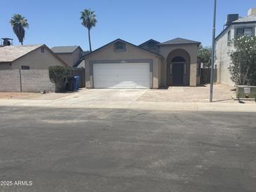 Charming single-Gathering home featuring a two-car garage and arched entryway at 3844 N 88Th Ln, Phoenix, AZ 85037