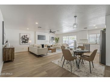 Open-concept living room with modern furnishings and decor and adjacent dining space at 16421 N 34Th Ave, Phoenix, AZ 85053