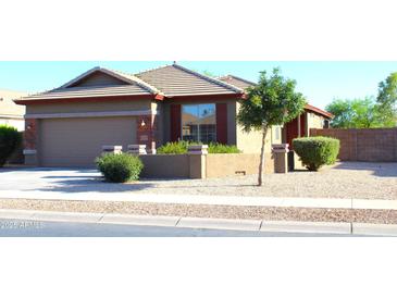 Charming single-story home with desert landscaping, tan stucco and brick accents at 21433 E Calle De Flores Ct, Queen Creek, AZ 85142
