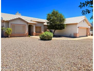 Charming single-story home featuring a desert landscaped yard and a two-car garage at 10722 W Quartz Dr, Casa Grande, AZ 85193