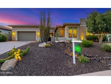 Beautifully landscaped front yard with desert plants, rock features, and modern home facade at dusk at 11796 W Creosote Dr, Peoria, AZ 85383