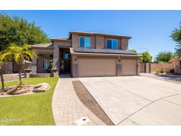 Charming two-story home featuring a three-car garage, desert landscaping, and a paver walkway at 1204 S Arroya Cir, Mesa, AZ 85206