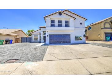 Two story home with a white exterior, desert landscaping, a two car garage and a gray brick driveway at 1853 N Rowen Cir, Mesa, AZ 85207