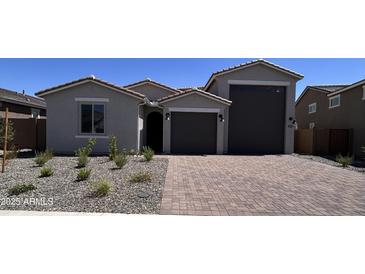 Charming single-story home featuring a brick driveway, desert landscaping, and a two-car garage at 18661 E Helian Dr, Gold Canyon, AZ 85118