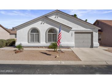 Charming single-story home featuring a two-car garage, arched windows, and neat desert landscaping at 1881 E Kerby Farms Rd, Chandler, AZ 85249