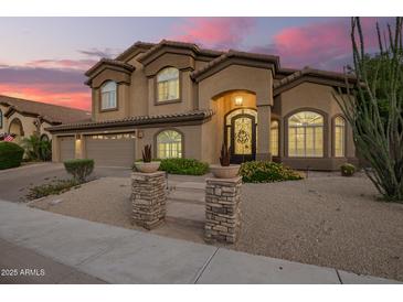Elegant two-story home with a three-car garage and desert landscaping, illuminated by a vibrant sunset sky at 1935 E Seminole Dr, Phoenix, AZ 85022