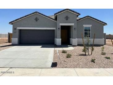 A charming single-story home with a gray exterior, a two-car garage, and well-maintained landscaping at 38105 W Bello Ln, Maricopa, AZ 85138