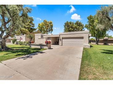 Charming single-story home with a two-car garage, mature trees, and a well-maintained front yard at 7832 E Via Marina --, Scottsdale, AZ 85258