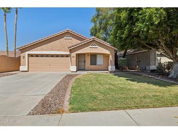 Charming single-Gathering home featuring a well-manicured lawn, a two-car garage, and desert landscaping at 1156 N San Benito Dr, Gilbert, AZ 85234