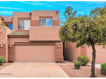 Two-story townhouse with a two-car garage, neutral tones, and desert landscaping in a well-maintained neighborhood at 1477 W Marlin Dr, Chandler, AZ 85286
