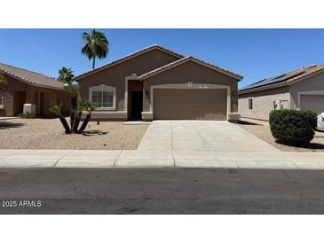 Charming single-story home with a desert landscape, a two-car garage and neutral-toned exterior paint at 15334 W Acapulco Ln, Surprise, AZ 85379