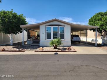 Charming home showcasing a covered carport and well-kept landscaping on a sunny day at 18026 N Cave Creek Rd # 16, Phoenix, AZ 85032