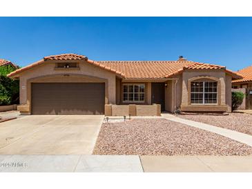 Single story home featuring a brown two car garage, tile roof, desert landscaping, and sidewalk leading to the front door at 4336 E Aspen Ave, Mesa, AZ 85201