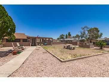 Expansive backyard featuring a large decorative rock area and a quaint stone picnic table set at 8602 N 41St Ave, Phoenix, AZ 85051