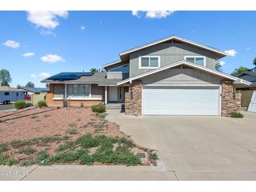 Charming two-story home features a two-car garage, solar panels and a low maintenance front yard at 15410 N 60Th Ave, Glendale, AZ 85306