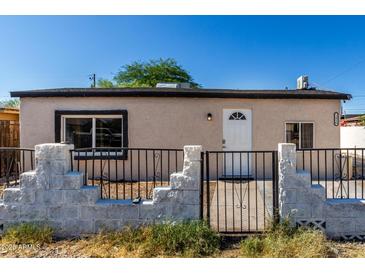 Charming single-story home featuring a secured front yard with decorative stone and wrought iron fencing at 1916 W Tonto St, Phoenix, AZ 85009