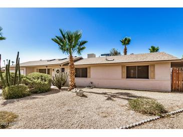 Charming home with desert landscaping, including palm trees and cacti, offering curb appeal at 2018 W Taro Ln, Phoenix, AZ 85027