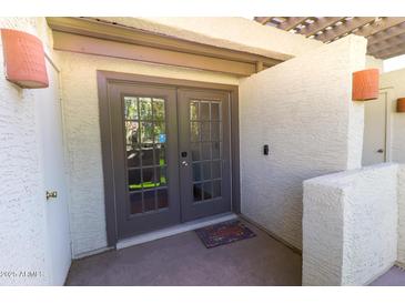 Inviting entryway with double doors, textured walls, and a welcome mat, offering a warm entrance to the home at 2333 E Southern Ave # 2033, Tempe, AZ 85282