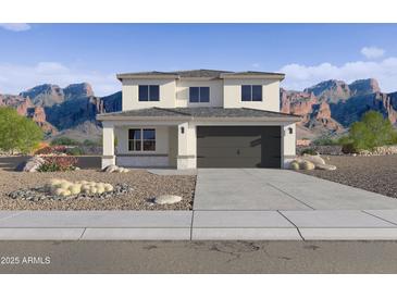 Two-story home featuring desert landscaping, a gray garage door, and situated in front of beautiful mountains at 24238 W Hacienda Ave, Buckeye, AZ 85326
