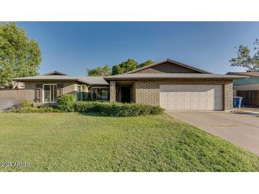 Charming single-story brick home with well-maintained landscaping and a spacious two-car garage at 717 W Manhatton Dr, Tempe, AZ 85282