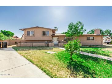 Traditional two-story home featuring a well-manicured lawn and mature landscaping at 840 N Acacia --, Mesa, AZ 85213