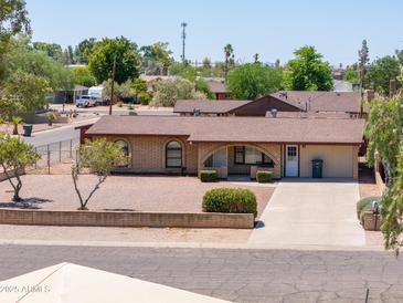 Charming single-story brick home with manicured landscaping, a spacious driveway, and a welcoming facade at 1109 N Walnut Dr, Casa Grande, AZ 85122