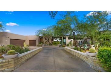 Desert landscaping and brick driveway lead to this charming, flat-roofed home with a two-car garage at 30600 N Pima Rd # 61, Scottsdale, AZ 85266