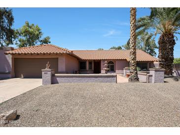 Charming single-story home with tile roof, desert landscaping, and a welcoming fountain in the front yard at 4854 E Blanche Dr, Scottsdale, AZ 85254
