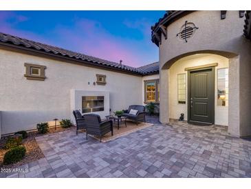 Private outdoor patio with a cozy seating area, fireplace and stylish hardscaping and lighting at 7415 W Lisbon Ln, Peoria, AZ 85381