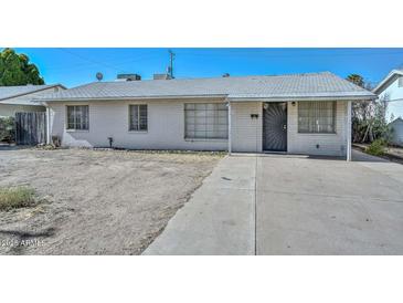 View of the home's exterior showcasing a well-maintained yard and charming architectural details at 829 E Echo Ln, Phoenix, AZ 85020